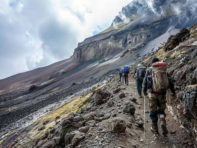 Trekkers ascending the rocky slopes of Ol Doinyo Lengai