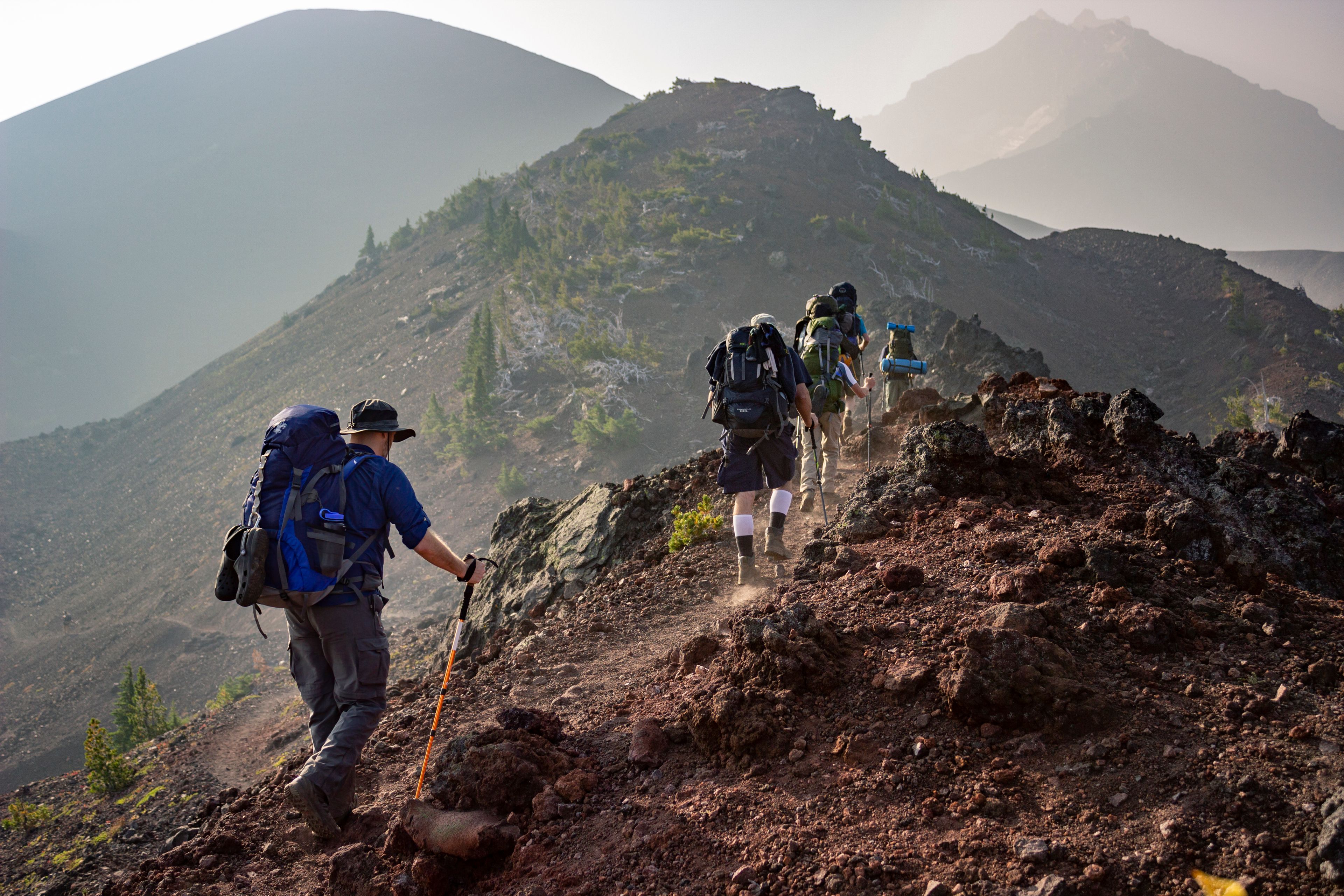 Hikers with backpacks ascending a steep rocky ridge on the Umbwe Route, Mount Kilimanjaro